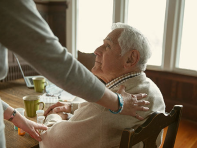 An elderly adult smiling at a helping hand.